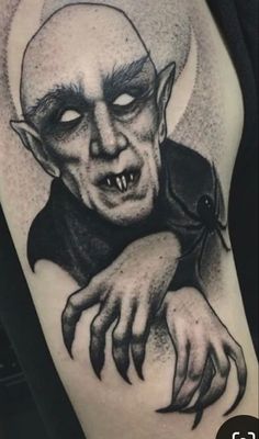 a black and white photo of a tattoo with a creepy face