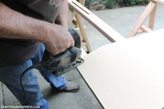 a man using a power tool to cut wood