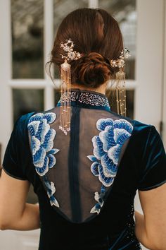 the back of a woman's dress with blue flowers on it