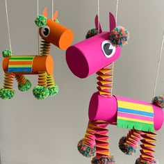 two colorful paper horses hanging from strings