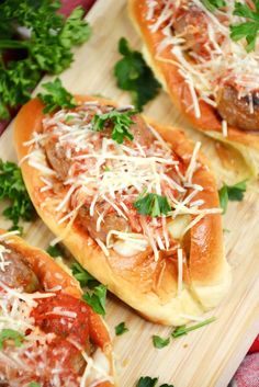 three stuffed buns with meat, cheese and parmesan on a cutting board