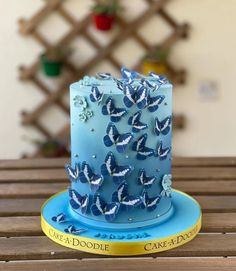 a blue cake with white butterflies on it