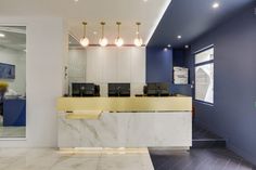 an office lobby with marble counter tops and blue accenting the walls, along with yellow accents