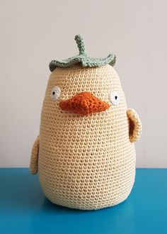 a crocheted stuffed bird sitting on top of a blue table