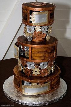 a three tiered wooden cake decorated with gears and flowers on it's sides