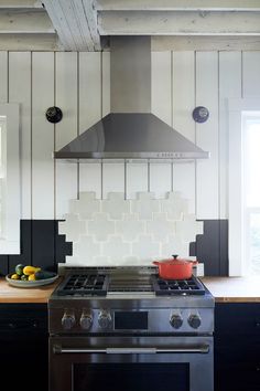 a stove top oven sitting inside of a kitchen next to a bowl with fruit on it