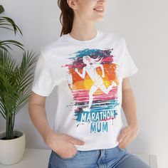 Celebrate the unstoppable spirit of marathon-running mums with our exclusive Marathon Mum Graphic T-Shirt. Crafted from premium quality cotton, this t-shirt provides a soft and comfortable fit, perfect for everyday wear. The design features a vibrant and dynamic graphic of a female runner set against a sunset-inspired backdrop, capturing the essence of determination and strength. This t-shirt is more than just a piece of clothing; it's a tribute to all the marathon mums out there who balance lif Cotton Short Sleeve T-shirt For Running, White Graphic Print T-shirt For Running, White Sporty Tops For Marathon, Sporty Graphic Print T-shirt For Marathon, Female Runner, Marathon Runner, Running Gifts, The Marathon, Marathon Runners