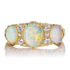 three opal and diamond ring in yellow gold with white diamonds on the sides,