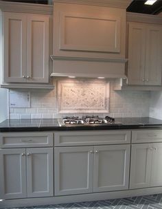 a kitchen with white cabinets and black counter tops