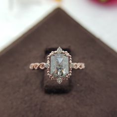 a fancy ring with an oval cut diamond in the center on a velvet box,