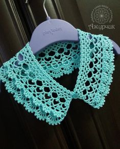 a blue crocheted scarf hanging from a hook