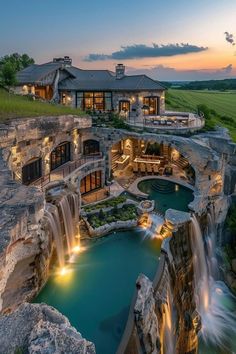 an aerial view of a house with a waterfall in the front yard and pool area