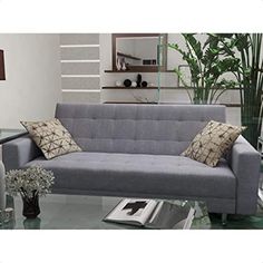 a gray couch sitting next to a glass table