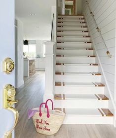 a basket sitting on the floor in front of a stair case next to a set of stairs