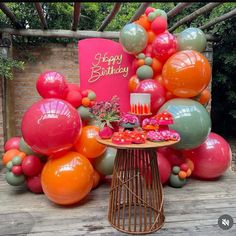 an outdoor birthday party with balloons and cake