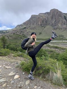 a woman standing on one leg with her legs spread out in the air while stretching