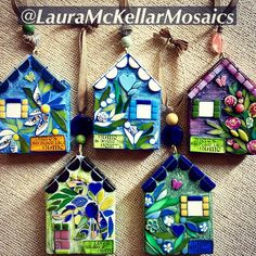 four small houses are hanging on the wall with flowers and leaves painted on their sides