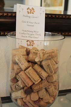 a wine glass filled with lots of corks next to a sign on the wall