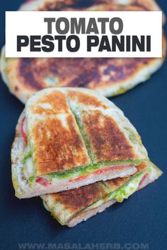 a sandwich cut in half on top of a blue surface with the words tomato pesto panini