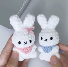 two small stuffed animals are held in their hands