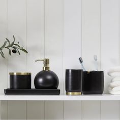 black and gold bathroom accessories sit on a shelf