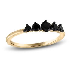 a gold ring with five black diamonds