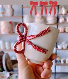 a person holding a cup with a red ribbon on it