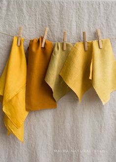 four different colors of cloth hanging on clothes pins