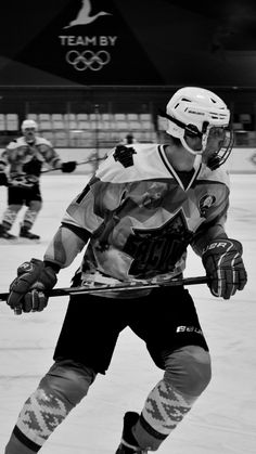 an ice hockey player on the ice with his stick in one hand and another behind him