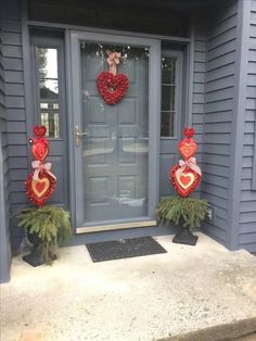 two valentine's day decorations in front of a door with wreaths on it