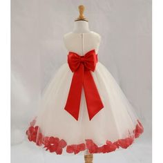 a white dress with red flowers and a big bow on the waistline is shown