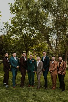 a group of men standing next to each other on top of a lush green field