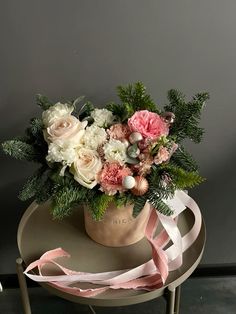 a bouquet of flowers sitting on top of a table next to a pink and white ribbon