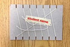 a piece of paper with the word student name taped to it on a wooden table