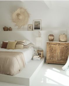 a bedroom with a bed, dresser and pictures on the wall