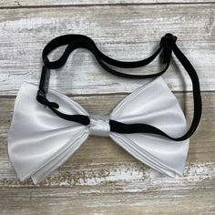 "Adults/Teens Elastic Suspender, Bow-tie All dimensions are approximate only Suspender Dimensions: Wide : 1.5\" (3.81cm) Adjustable from 25\" 63.5cm - 38\" (96.52cm) Bow Tie Dimensions: Length: 12cm (4.7 inches) Height (Widest Point): 6cm (2.36 inches) Height (Narrowest Point): 2.3cm (0.90 inches) Length of Bow Tie Strap at full length: 48cm (18.89 inches)" Fitted Pre-tied Bow For Party, White Ties For Black Tie Events, White Bow Tie For Black-tie Events, Fitted Pre-tied Tie For Party, White Bow Tie For Black Tie Events, Adjustable White Bow For Wedding, Classic White Bow Tie For Party, White Adjustable Bow For Wedding, Classic White Adjustable Bow Tie