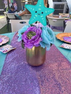 a starfish centerpiece with purple and blue flowers