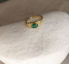 Stunning cocktail ring handcrafted with 18K (750) yellow gold features an oval natural Emerald gemstone on a high prong setting.  The Emerald is elegantly surrounded with shimmering Diamonds. Emerald 0.70 ct, dimension 8 mm x 5 mm Diamonds total 0.20 ct Top of ring height 5 mm Top of ring width 8 mm Band width 1.8 mm Size 7.5 US/55.5 Europe (This ring may be sized.  For ring sizing please allow extra time for shipping) Handcrafted one of a kind.  Made in Greece.  All items are delivered ready fo Gold Emerald Ring With Oval Gemstone, Gold Oval Emerald Gemstone Ring, Gold Diamond Ring With Oval Cabochon Gemstone, Gold Oval Cabochon Diamond Ring With Gemstone, Yellow Gold Oval Emerald Birthstone Ring, Oval Yellow Gold Emerald Ring As Birthstone, Oval Yellow Gold Emerald Ring With Birthstone, 22k Yellow Gold Emerald Ring, Oval Gold Emerald Ring Fine Jewelry