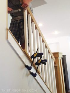 a man is standing on the stairs with tools in his hand and looking at something behind him