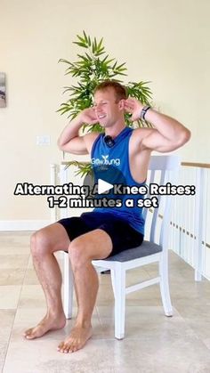 a man sitting on top of a chair next to a plant