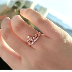 a woman's hand with a gold ring on top of it and a diamond in the middle