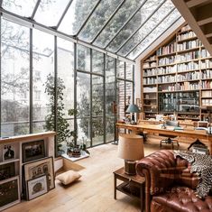 a living room filled with lots of furniture and bookshelves next to a window