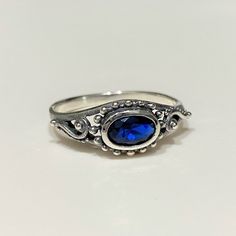 Sterling Silver Blue Sapphire Filigree Ring...Marked 925...Total of weights 1.8gramsMeasure of face 7MMMM...It's in very good condition. Jewelry Sapphire, Blue Silver Ring, Silver And Blue Ring, Oval Blue Sapphire Ring Stamped 925, Oval Blue Sterling Silver Stackable Rings, Blue Sapphire Ring Stamped 925, Blue Birthstone Ring In Sterling Silver, Adjustable Blue Birthstone Ring In Sterling Silver, Blue Sterling Silver Filigree Promise Ring