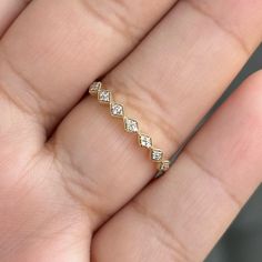 a woman's hand with a diamond ring on top of her finger, showing the band