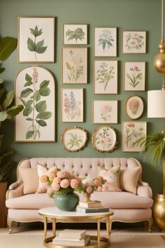 a living room with green walls and pictures on the wall, pink couches in front of a coffee table