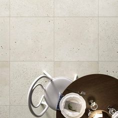 a coffee table and chair in front of a white tiled wall