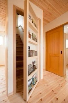 an empty room with wooden floors and white walls, has bookshelves on the wall