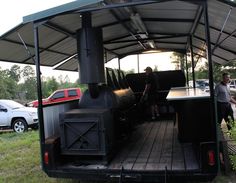 a man standing in the back of a truck with an oven on it's flatbed