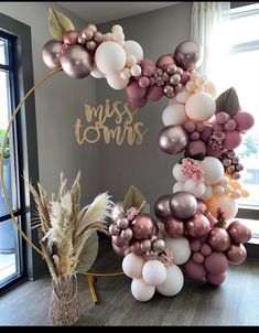 the balloon arch is decorated with pink, gold and white balloons