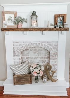 a white fireplace with flowers and candles on top of it, along with other decor items